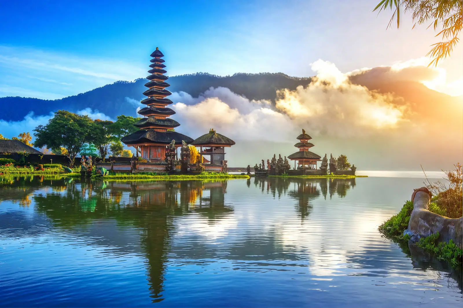 Sunrise over the highlands of Bali, with a temple silhouetted against the mist.